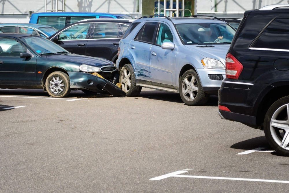 a couple of cars that are in a parking lot after having crashed