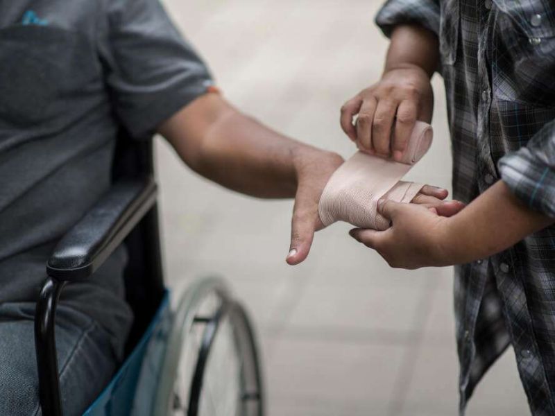 Person in wheelchair receiving arm bandage.