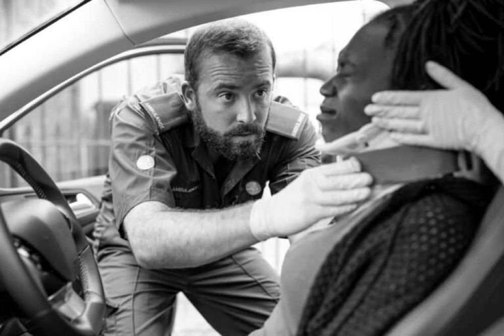 Paramedic assists car accident victim with neck brace for safety and care.