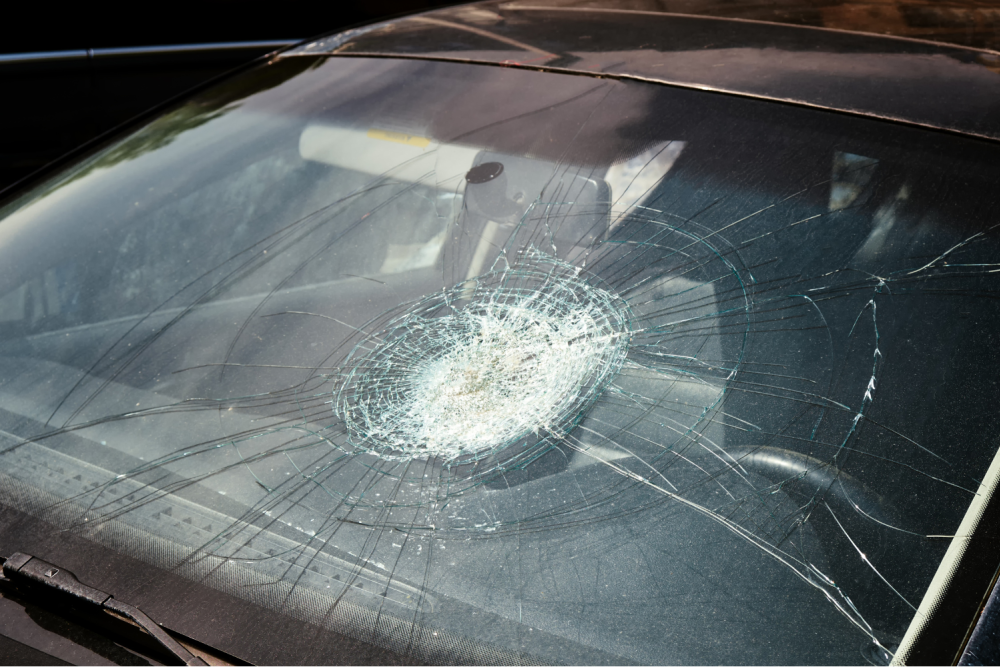 Cracked windshield from a car accident in Fort Lauderdale, symbolizing the aftermath of a collision and potential injuries like a concussion.