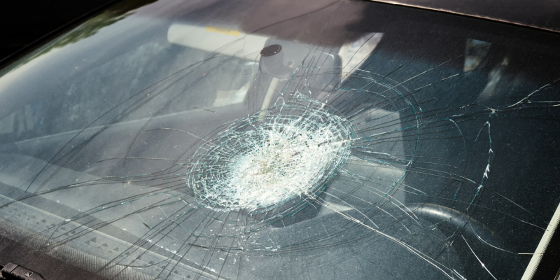 Cracked windshield from a car accident in Fort Lauderdale, symbolizing the aftermath of a collision and potential injuries like a concussion.
