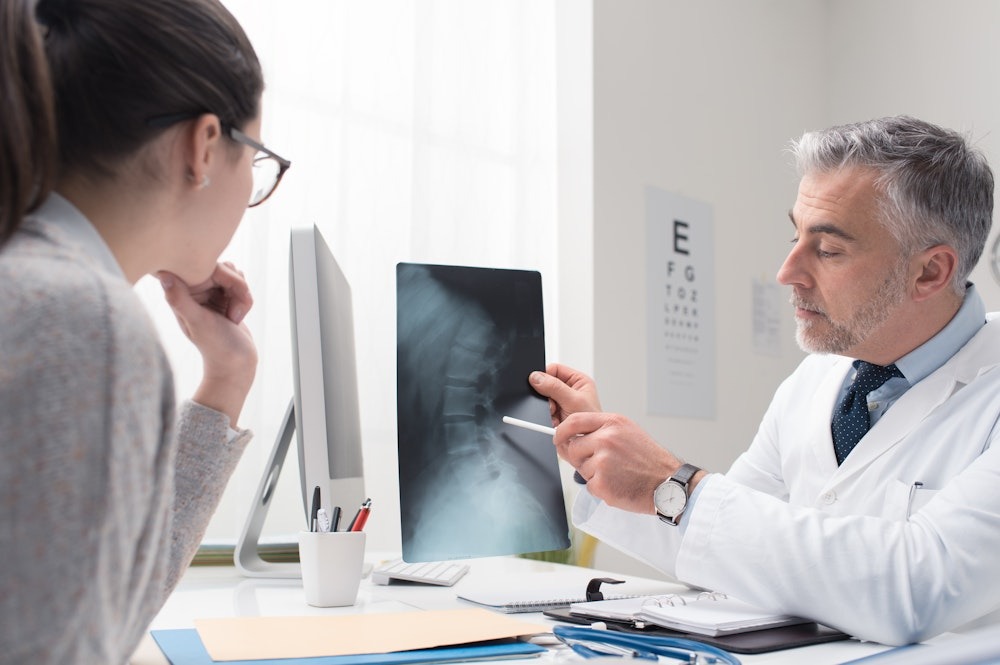 spinal-injury – Personal Injury Lawyer in Fort Lauderdale Doctor explaining X-ray results to a patient in a medical office setting.