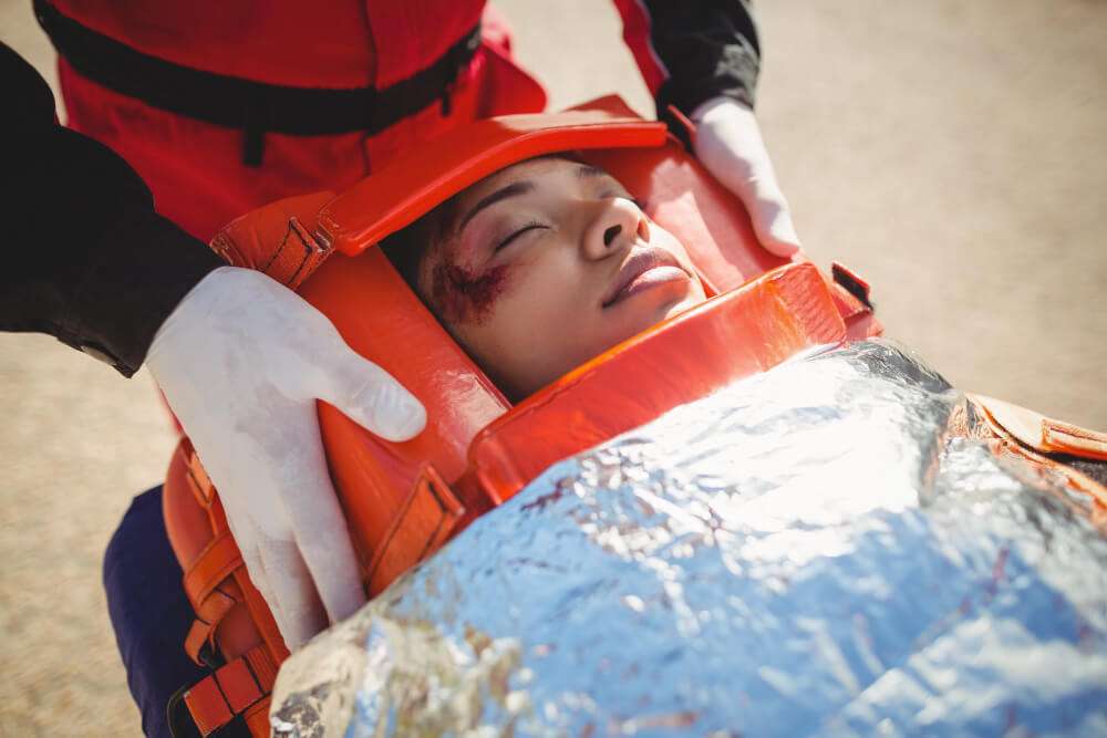 Rescue worker assisting injured person with head brace