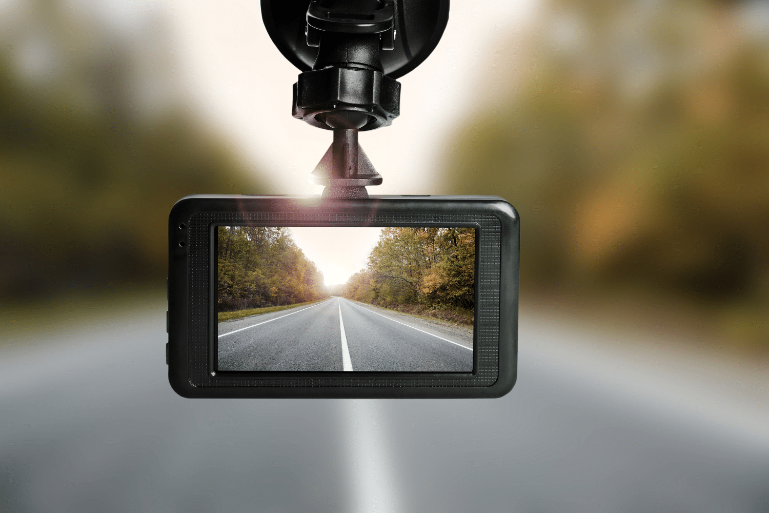 Close-up of a dashboard camera recording a road view through a car windshield.